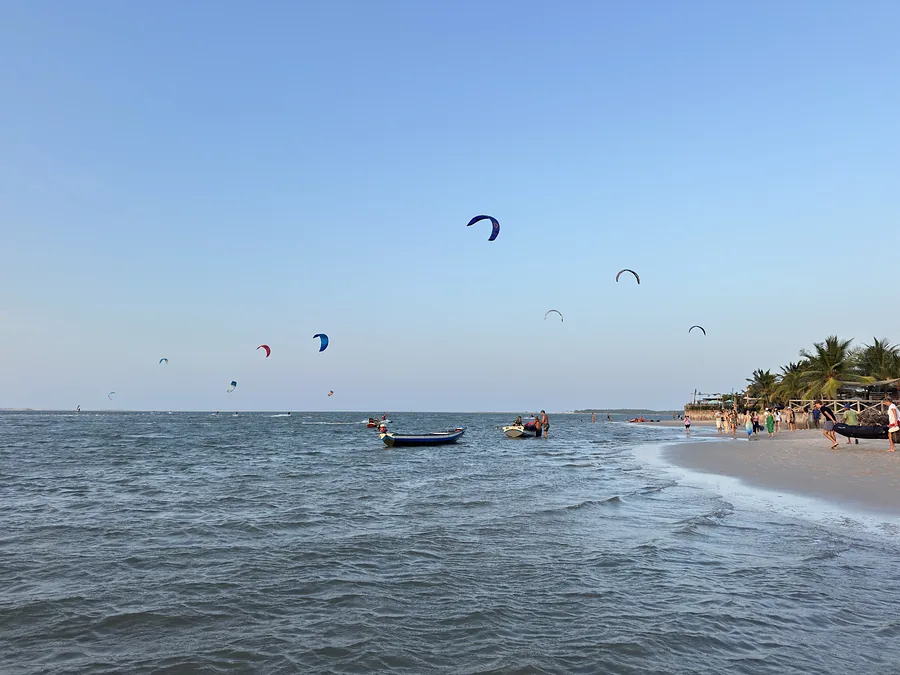 Praia de Atins com kites no céu e barcos na beira