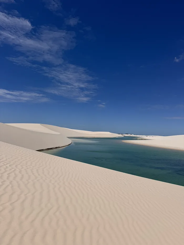 Dunas e uma lagoa de água azul nos Lençóis Maranhenses